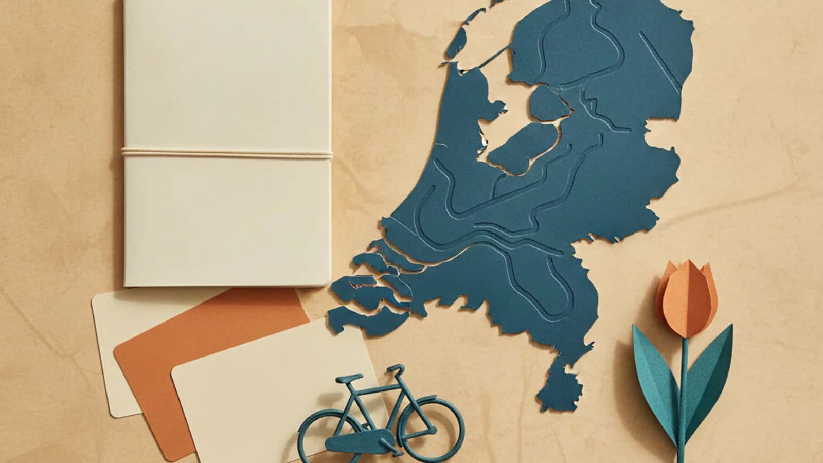 Stilisierte Karte der Niederlande neben einem Notizbuch, einem Fahrrad und einer Tulpe