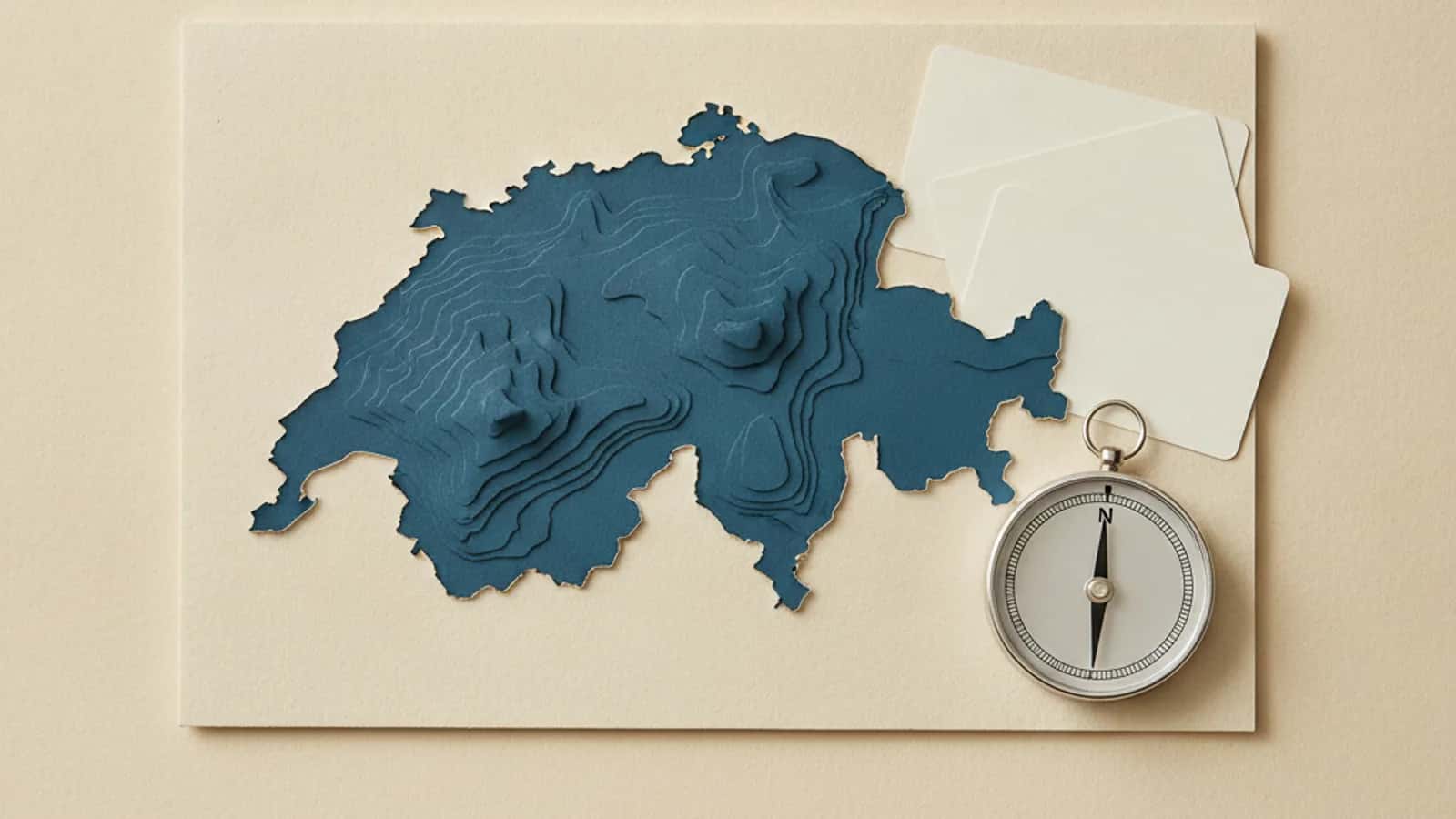 Stilisierte Karte der Schweiz neben blanken Karten und einem Kompass